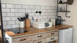 Et køkken med et hvidt flisebordsplade, en træbordplade og et hvidt køleskab.