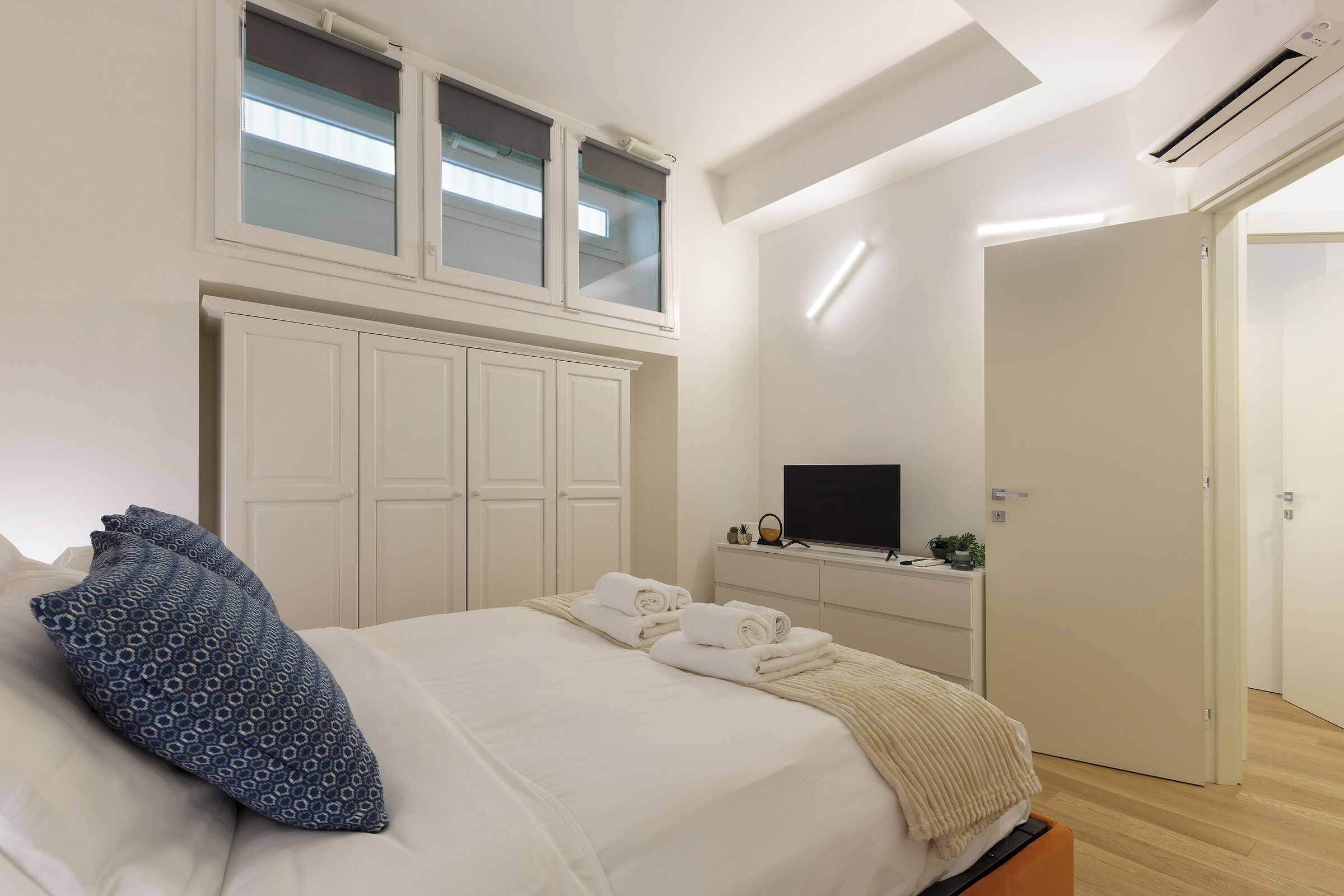 Une chambre à coucher avec un lit, une télévision et une armoire.