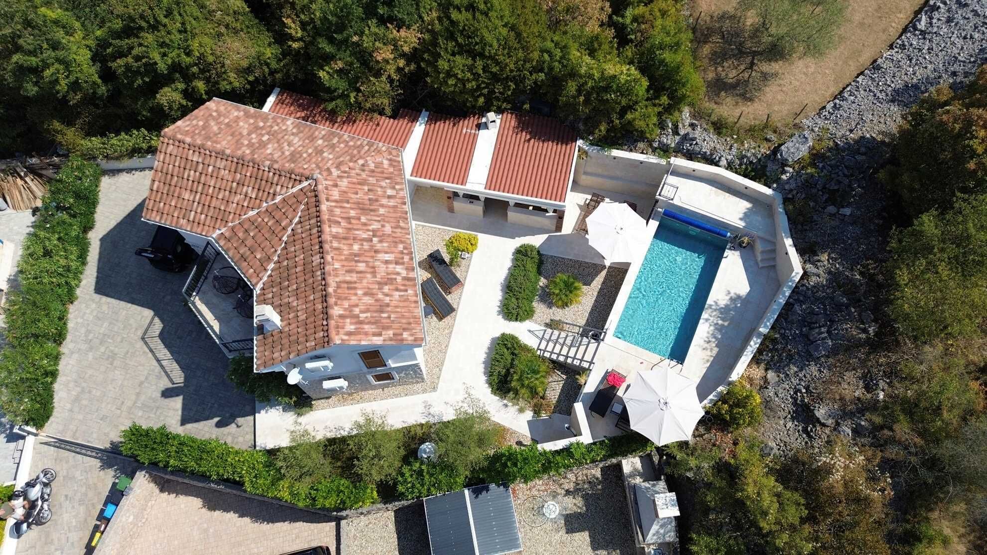A residential property with a swimming pool, a covered patio, and a detached garage.