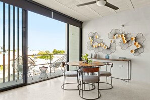 Ein moderner Essbereich mit einem runden Tisch, Stühlen und einem Balkon mit Blick.