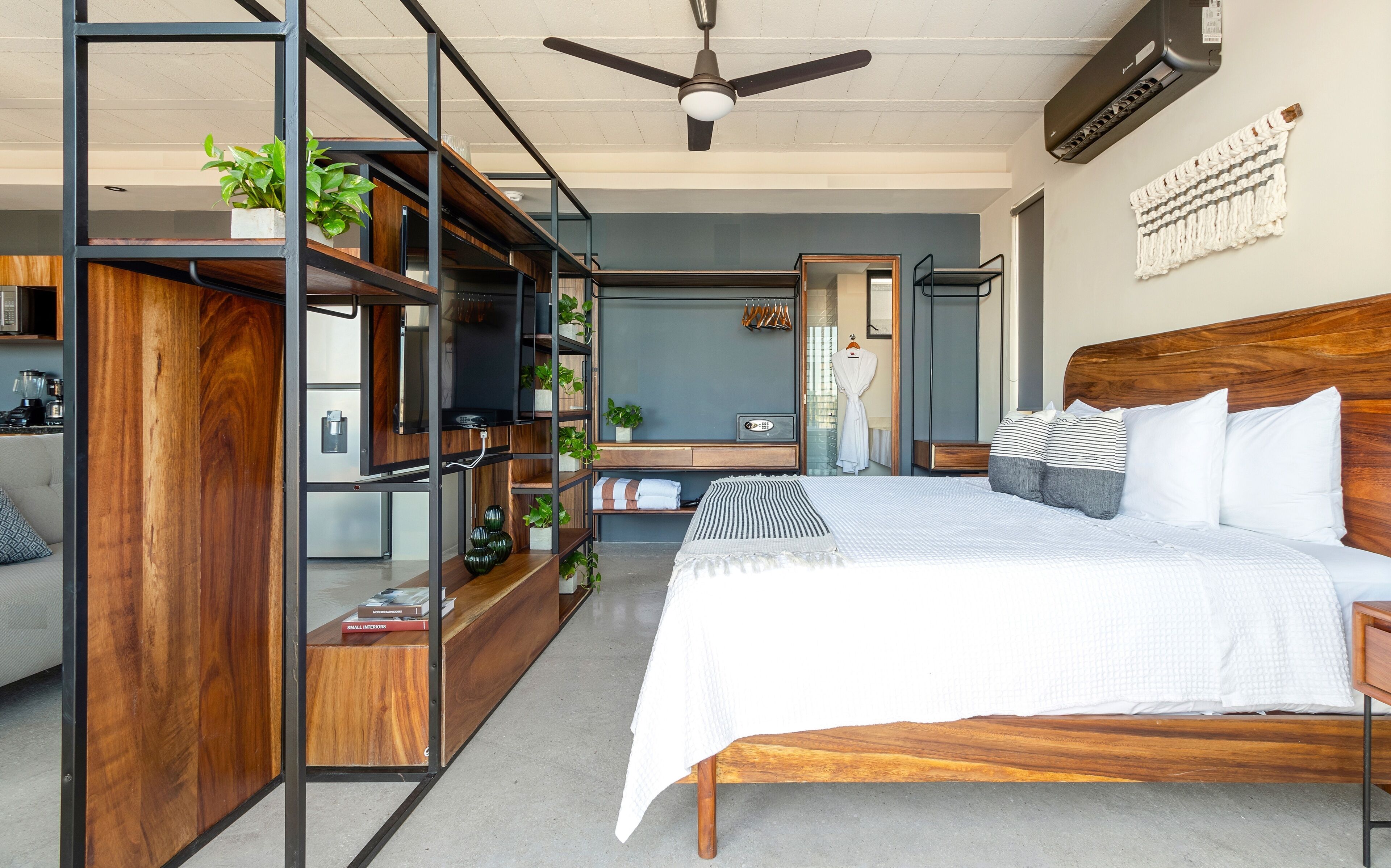A modern bedroom with a wooden bed, a built-in TV, and a ceiling fan.