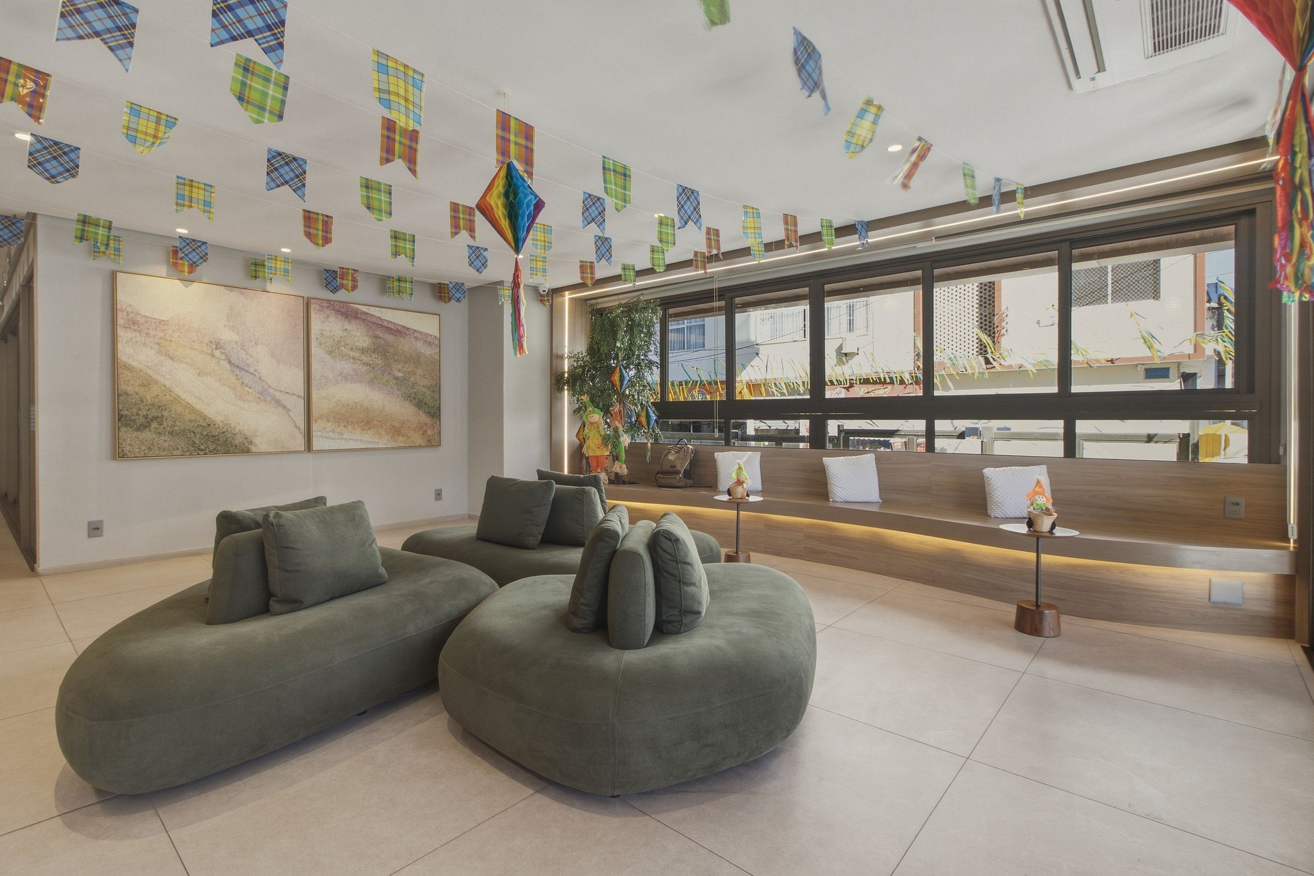 A modern interior with sectional sofas, a large abstract painting, and a reception desk.
