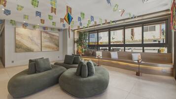 A modern interior with sectional sofas, a large abstract painting, and a reception desk.