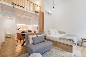 Eine moderne Wohnung mit Schlafgalerie, Essbereich und Küchenzeile.