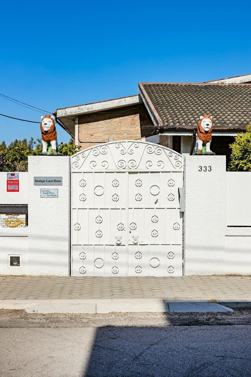 A gated entrance with a decorative gate, a sign reading 'Boutique Guest House,' and a number '333' on the wall.