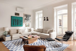 Ein modernes Wohnzimmer mit einer Couch, einem Couchtisch und einem schwarzen Ledersessel.