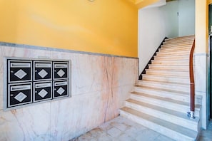 A staircase with marble walls and a yellow wall. - Twin Room @ Guest Inn 1 Boutique House (campo pequeno)