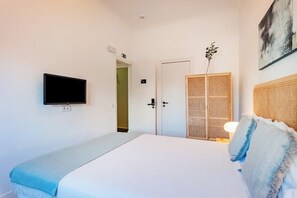 A bedroom with a bed, a television, a wardrobe, and a door leading to another room. - Double Room @ Guest Inn 2 Boutique House (campo pequeno)
