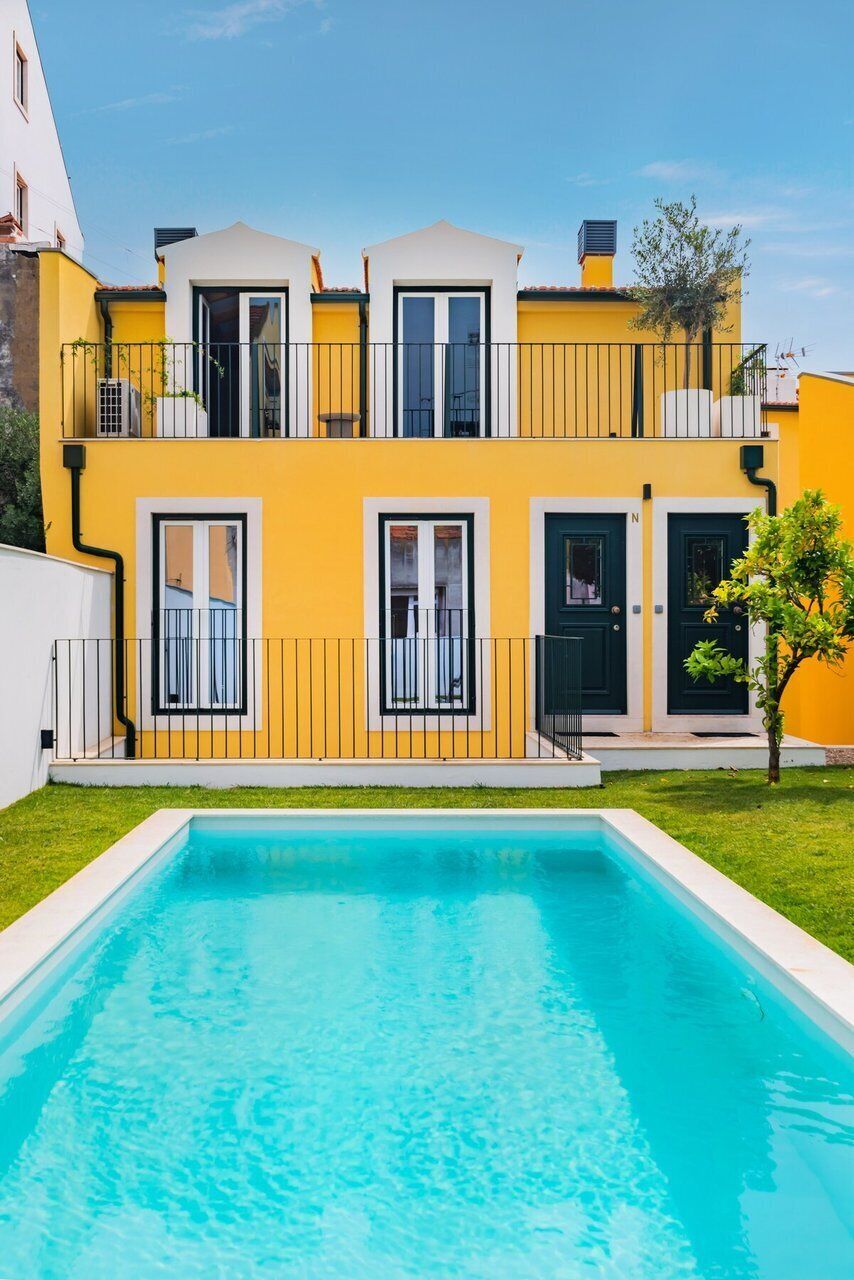 Un bâtiment à deux étages avec une piscine devant.