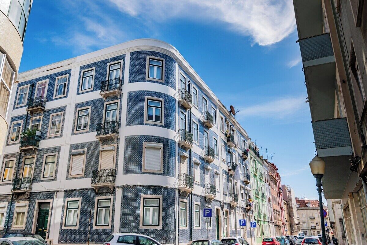 Ein mehrstöckiges Gebäude mit Balkonen, einem Parkschild und blauem Himmel.