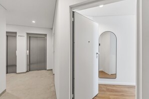 A hallway with three closed doors labeled 'PISO 3', a white wall, and a wooden floor. - Sage 1BR | Balconies, AC & Parking (Porto)