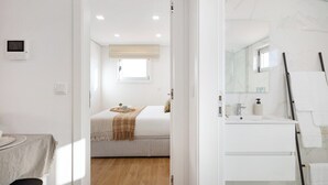 A bedroom with a bed, bedside table, and a window. - Matosinhos Seaside Comfy Flat (Matosinhos)