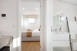 Een slaapkamer met een bed, nachtkastje en raam.