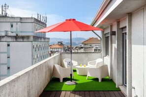 A balcony with white chairs, a red umbrella, and a small table with drinks. - Blue Terrace Porto (Porto)