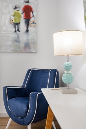 A modern room with a blue chair, a white table, and a lamp with a textured base. - Blue Terrace Porto (Porto)