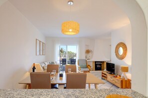 Ein modernes Wohnzimmer mit Essbereich, Kamin und Fernseher.