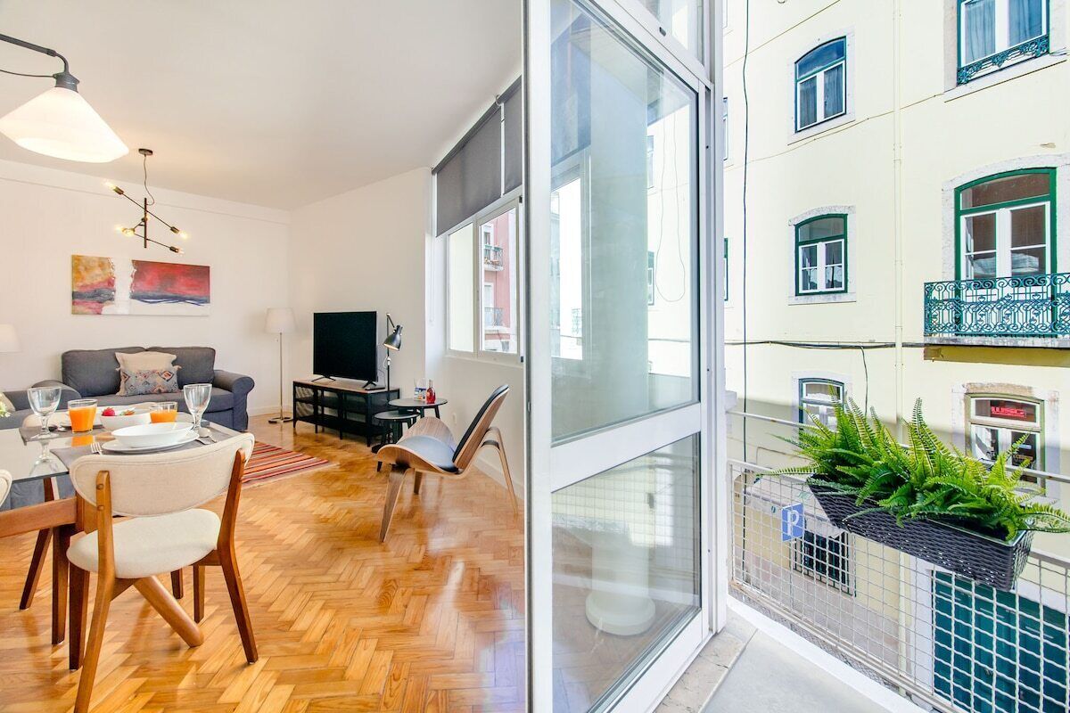 Eine moderne Wohnung mit Essbereich, Wohnzimmer und einem Balkon mit Pflanzen.
