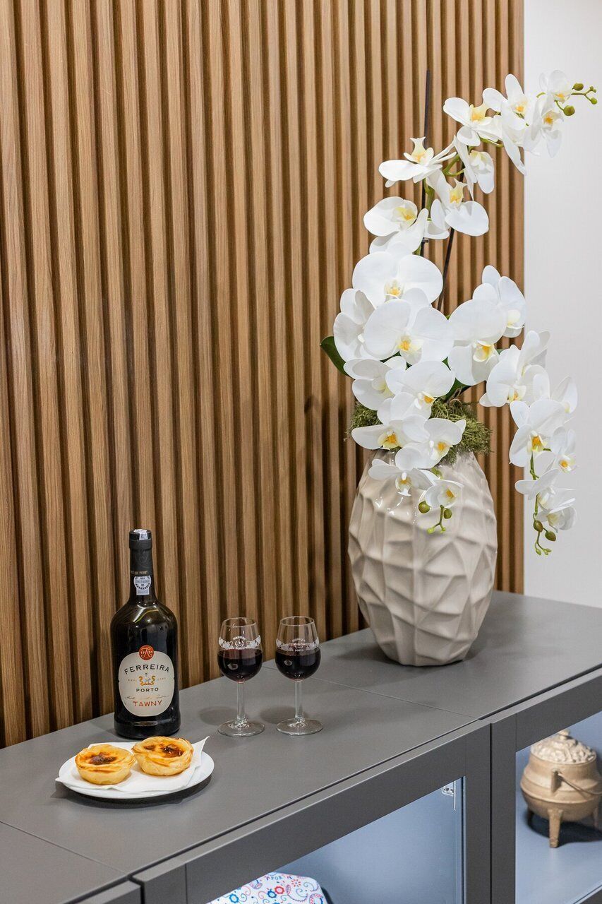 A table with a bottle of wine, two glasses, and pastries.