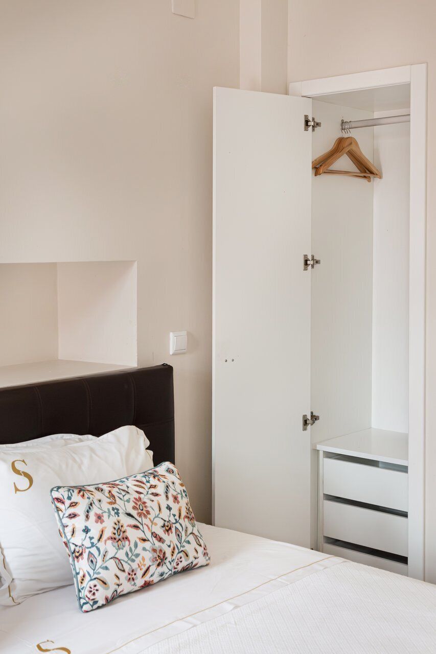 Una camera da letto con un letto, un armadio e un'asta appendiabiti.