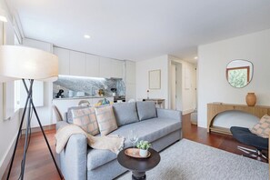 Een moderne woonkamer met een grijze bank, een salontafel en een lamp.