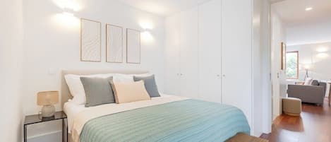 A bedroom with a bed, bedside table, and wall-mounted light fixtures.
