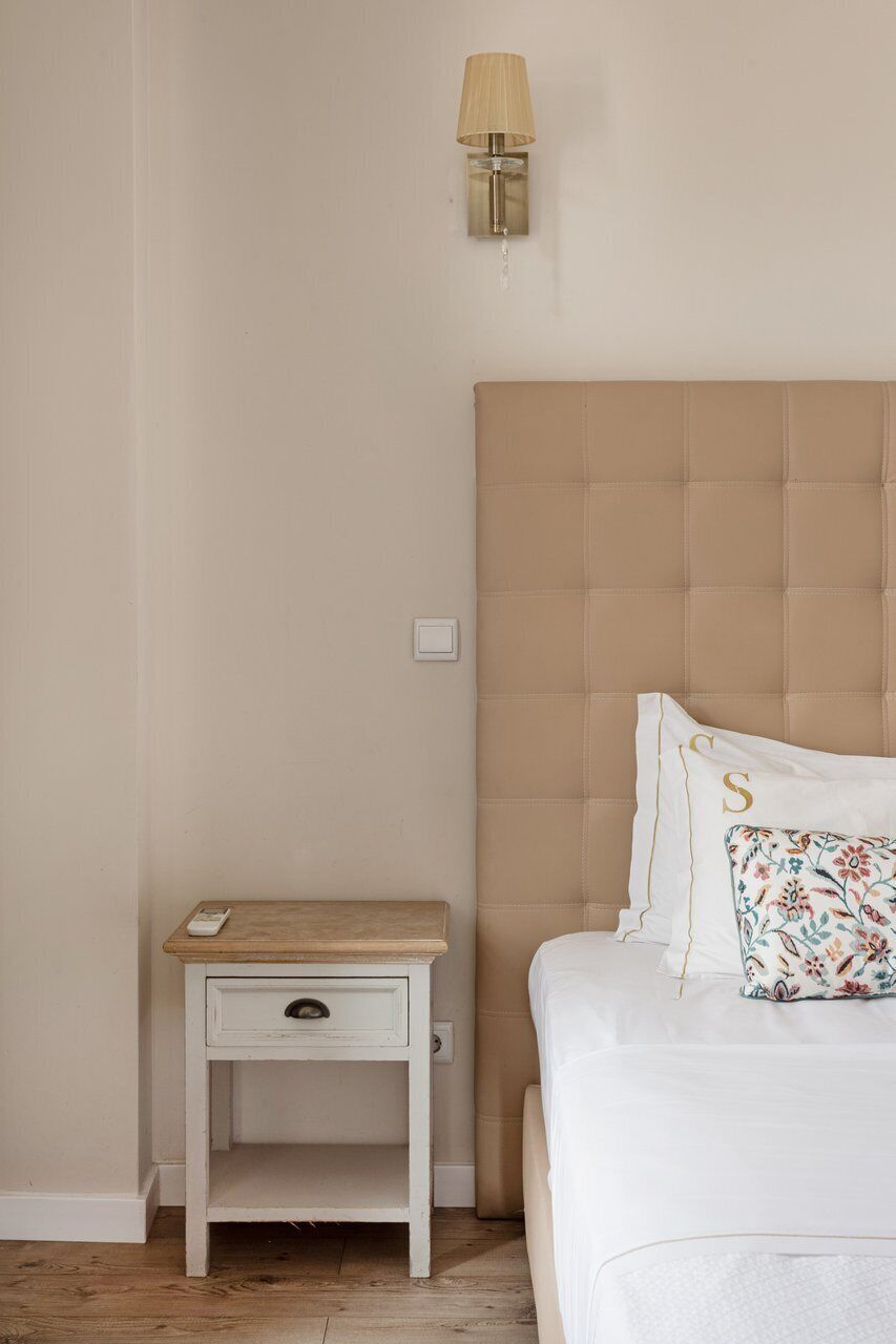 Un dormitorio con una cama, una mesita de noche, una lámpara e interruptor de luz.