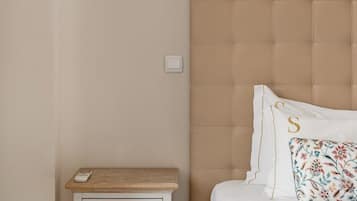 Un dormitorio con una cama, una mesita de noche, una lámpara e interruptor de luz.