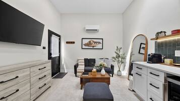 A modern living room with a sofa, coffee table, and a flat-screen TV.