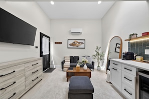 A modern living room with a sofa, coffee table, and a flat-screen TV.