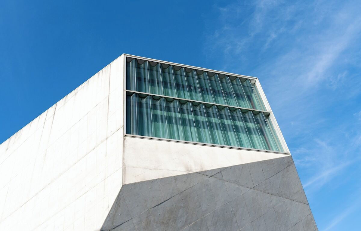 Um edifício moderno com fachada geométrica e grandes janelas de vidro.