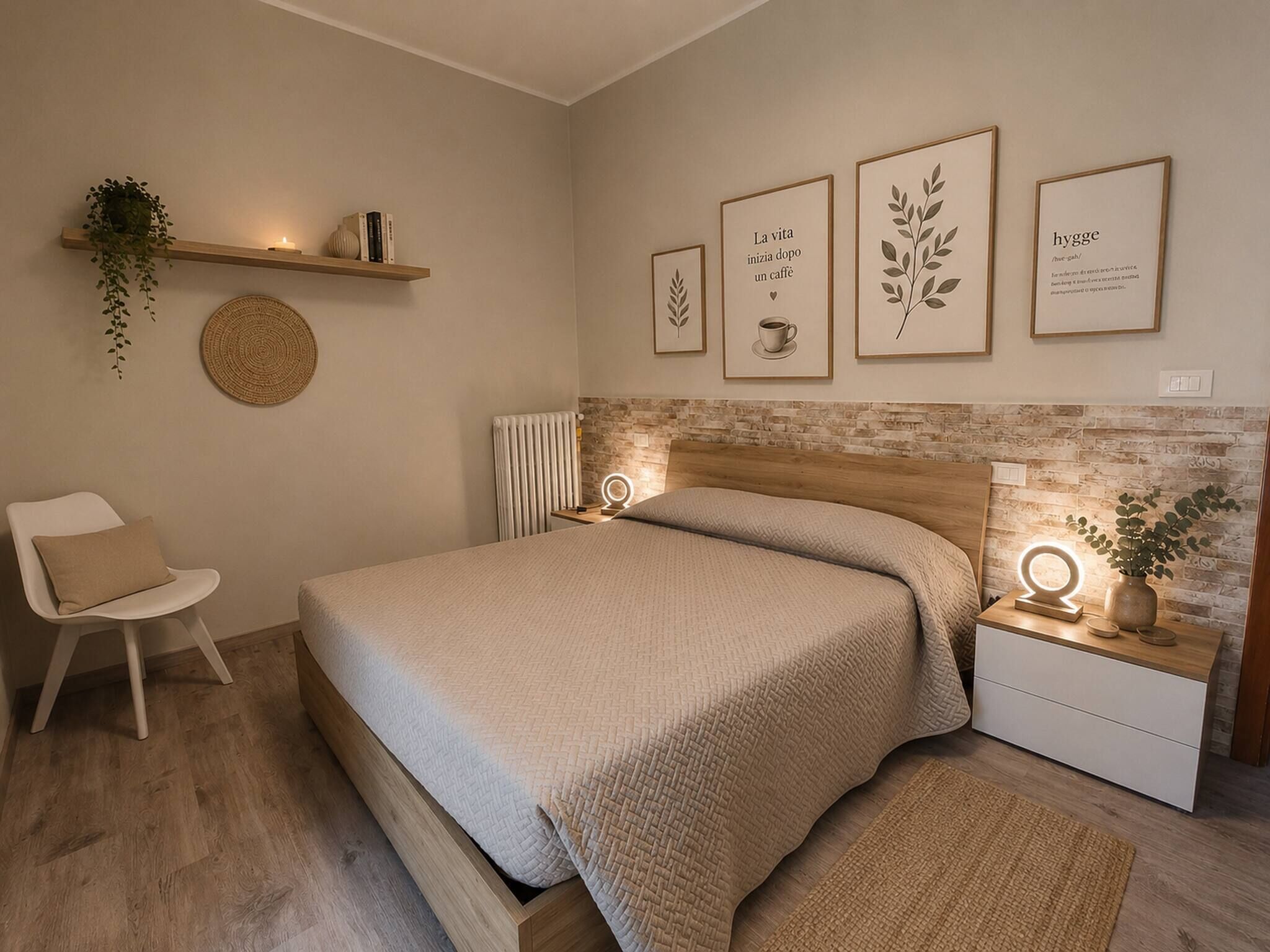 A bedroom with a bed, bedside tables, a chair, a wall-mounted shelf with a plant, and framed artwork.