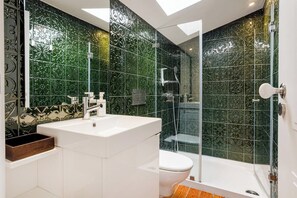 Un baño moderno con lavamanos grande, inodoro y zona de ducha.