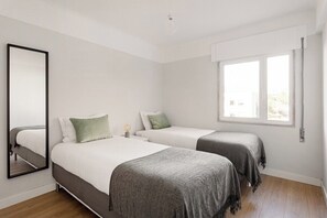 A bedroom with two beds, a window, and a mirror. - WFH Urban Retreat @ Carnide (Lisbon)
