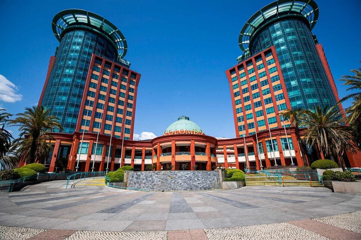 A modern building with two cylindrical towers, a central dome, and a symmetrical facade.