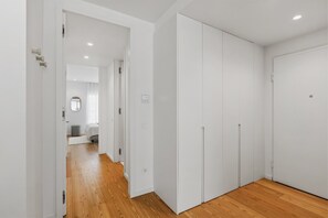 A hallway with wooden flooring, white walls, and a large closet with sliding doors. - Sal D'Ouro | Terrace & Beach (Vila Nova de Gaia)