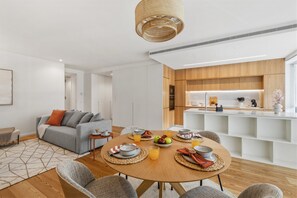 A modern living space with a dining area, kitchen, and seating. - Sal D'Ouro | Terrace & Beach (Vila Nova de Gaia)