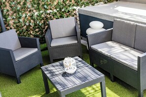 Outdoor wicker furniture with cushions, a small table, and a lantern. - Porto City Holidays by Douro River (Porto)