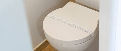 A white toilet with a checkered tile wall behind it.
