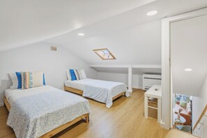 A compact bedroom with two beds, a skylight, a small table, and a white wardrobe. - Sunny House with Private Terrace | Gaia (Vila Nova de Gaia)