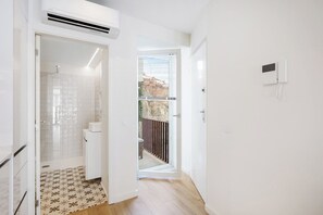 Ein modernes Badezimmer mit Dusche, Toilette und einem gemusterten Boden.