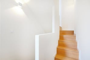 Eine Treppe mit Holzstufen und weißen Wänden.