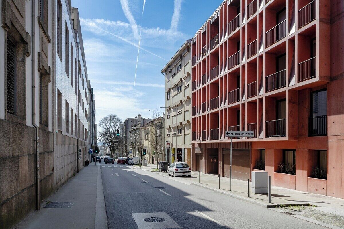 Una calle con edificios, un letrero de clínica veterinaria y un cielo despejado.