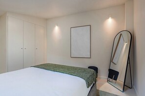 A bedroom with a bed, a wardrobe, a mirror, and a framed picture on the wall. - Urban Loft @ Terracotta Collection (Porto)