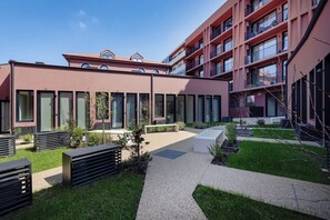 A modern building with a courtyard, outdoor seating, and a pathway. - Urban Loft @ Terracotta Collection (Porto)