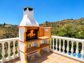 A brick-built outdoor grill with a chimney, a bench, and a view of a hilly landscape. - Villa Cecilia con Vistas by At Home Costa del Sol (Torrox)