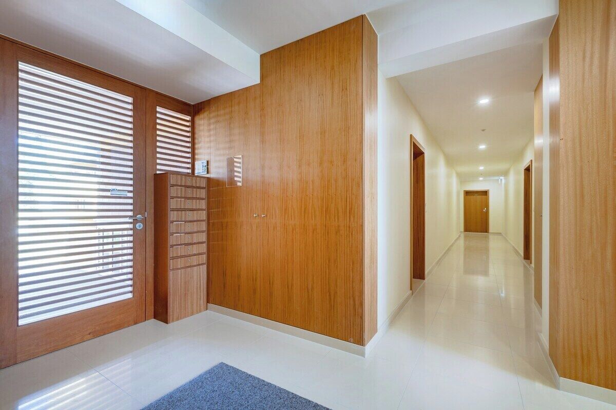 A hallway with wooden doors and a tiled floor.