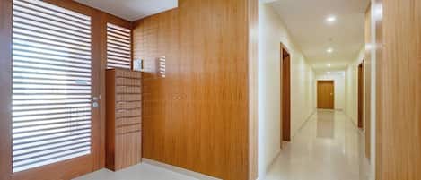 A hallway with wooden doors and a tiled floor.