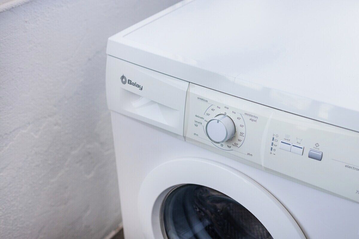 A white washing machine with a control panel featuring temperature settings and a 'Delicate' mode.