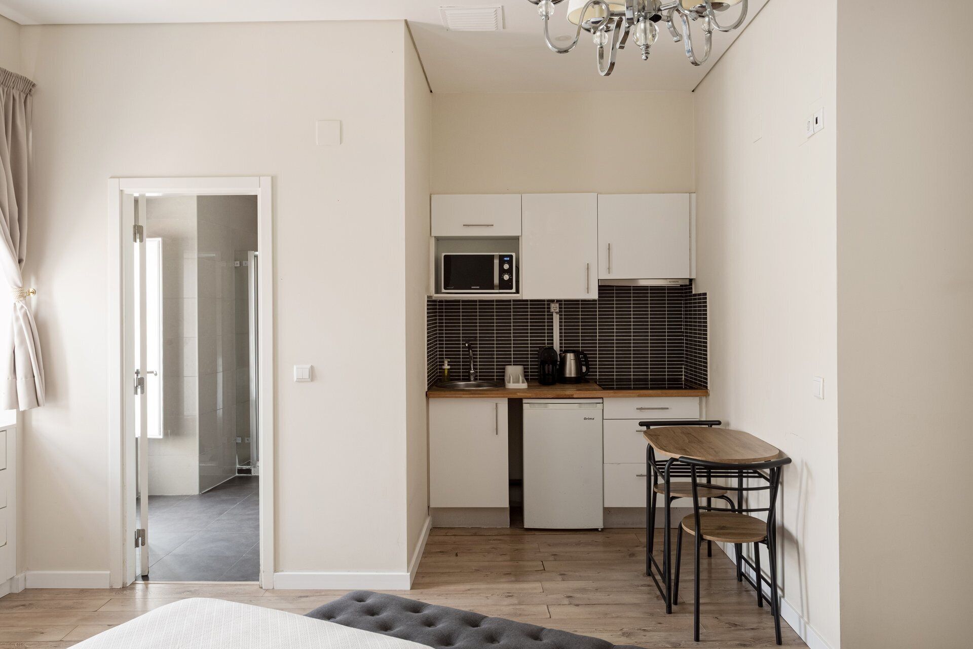 A compact kitchen with a microwave, coffee maker, and a small refrigerator.