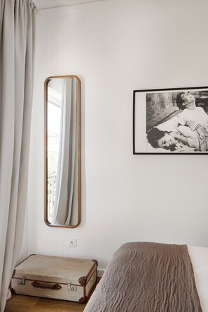 A room with a bed, a suitcase, a mirror, and a framed picture on the wall. - Seaside Family Stays | Walk to the Beach, Caxias (Caxias)
